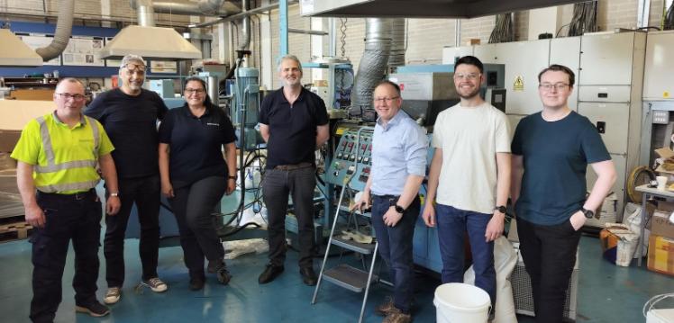 Group of course participants standing beside Laboratory Extrusion Equipment