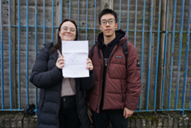 Anna and Jackson holding up a piece of paper