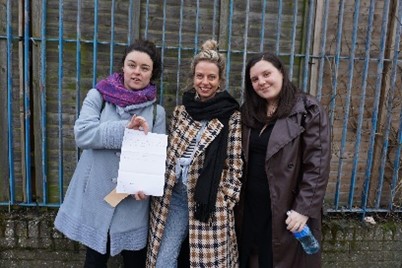 Bex, Jenny, and Sophie holding up a piece of paper