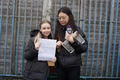 Amaria and Mihua holding up a piece of paper