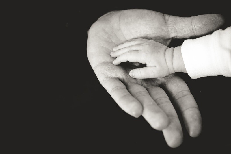 a baby's hand touching an adult hand