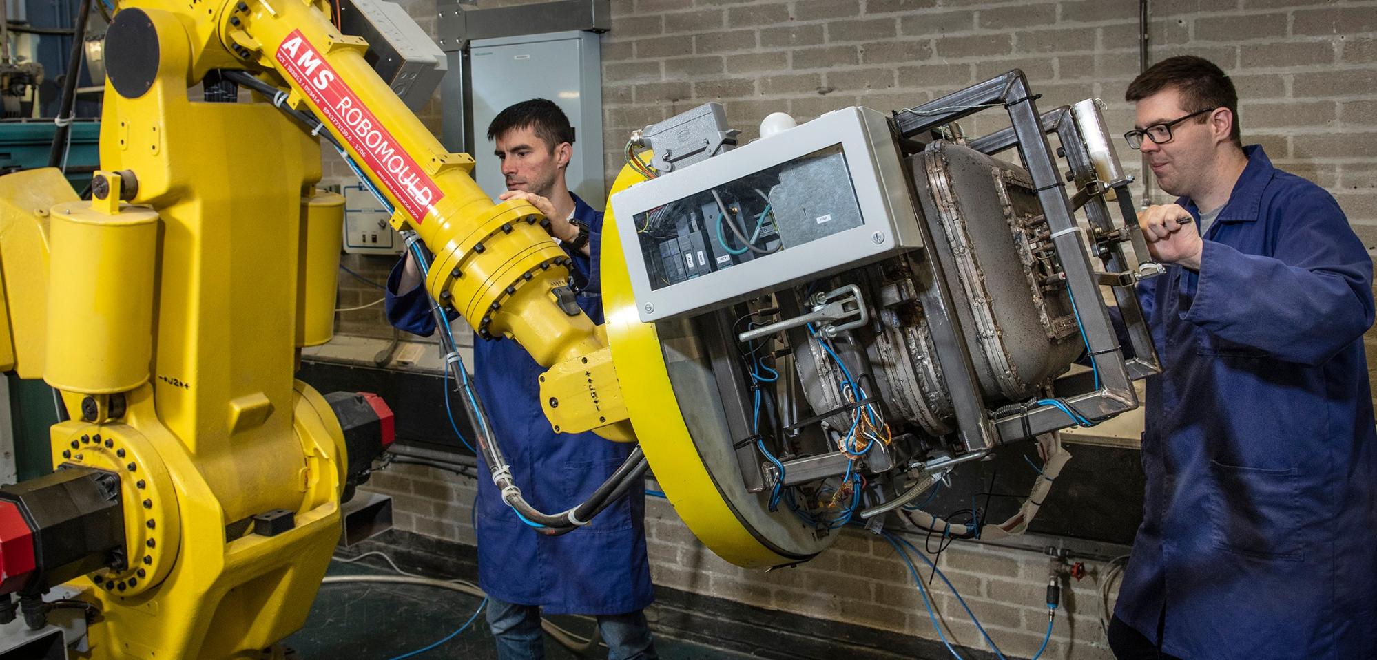 A picture of operators at a rotational moulding robot.