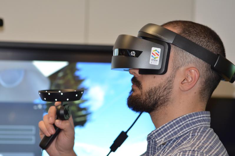 An adult bald male wears VR equipment 