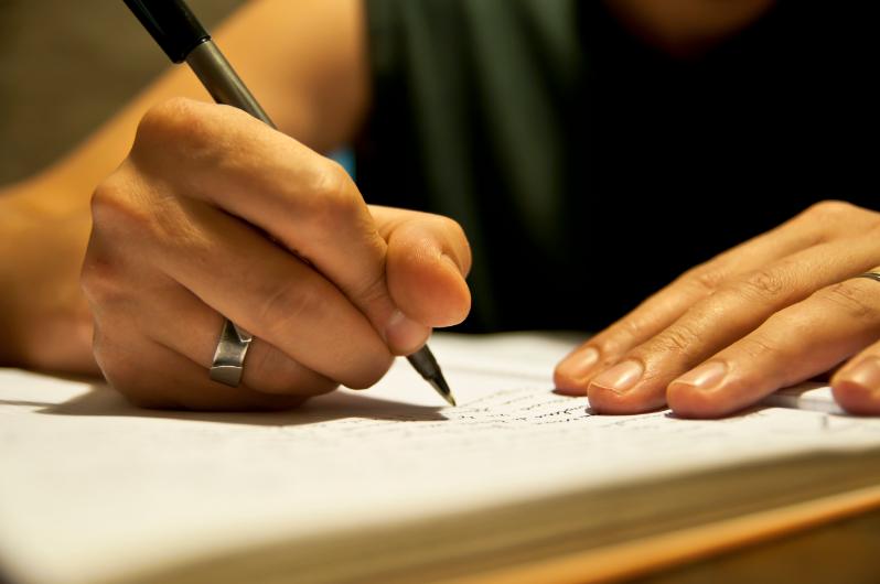 A female person's hands seem to be taking notes in a notebook