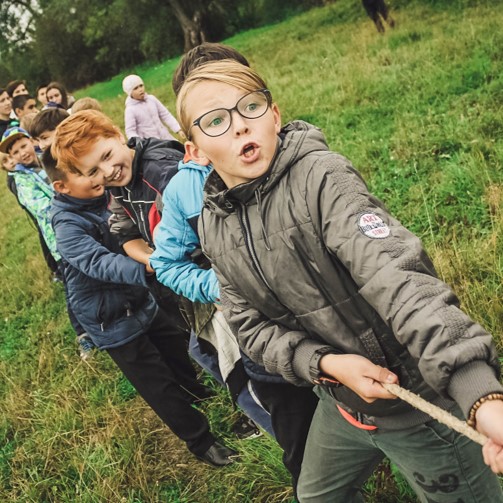 A group of kids are pulling a rope