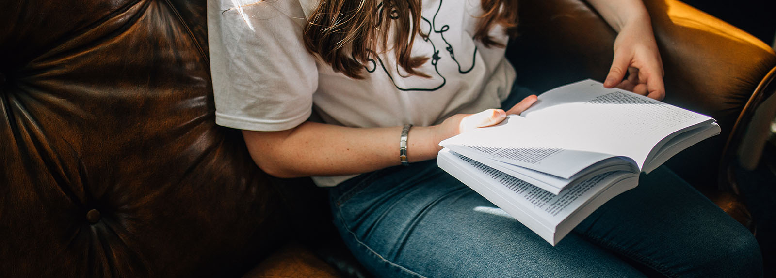 Female student with an open book reading a page