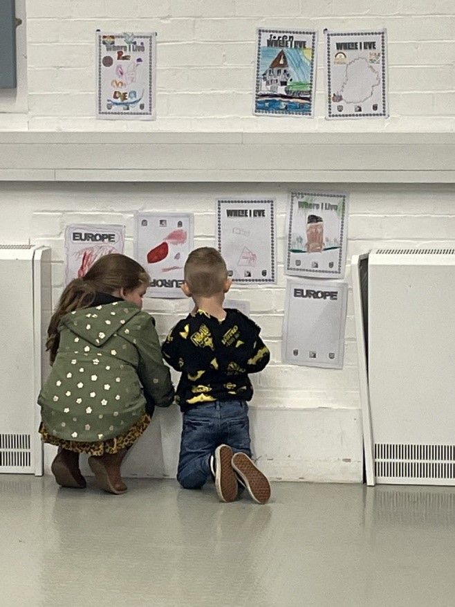 two children looking at drawings