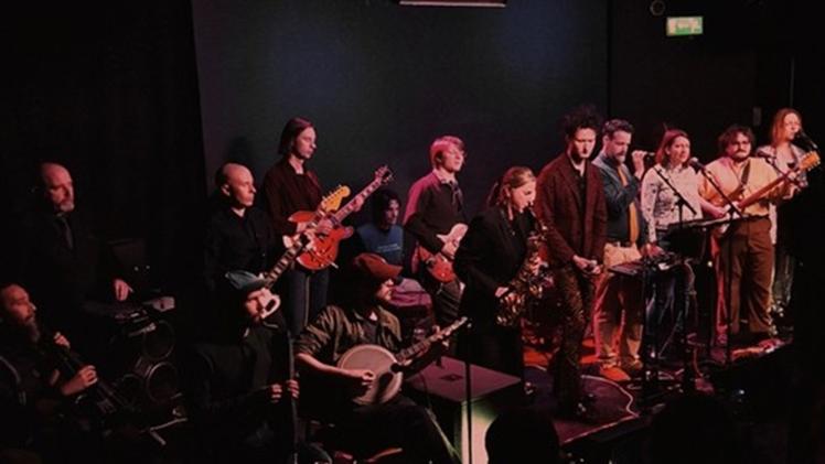 Group of people playing instruments in a dark venue