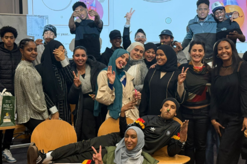 a group of young people smiling and posing for the camera