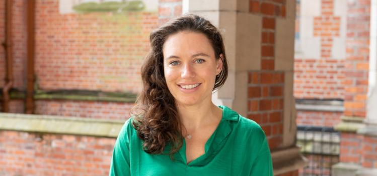 a dark haired woman wearing a green top