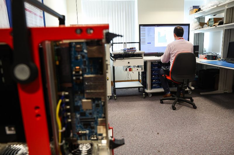 Person working on a computer at CSIT, Queen’s University Belfast, analysing data on a large screen in a cybersecurity research lab.