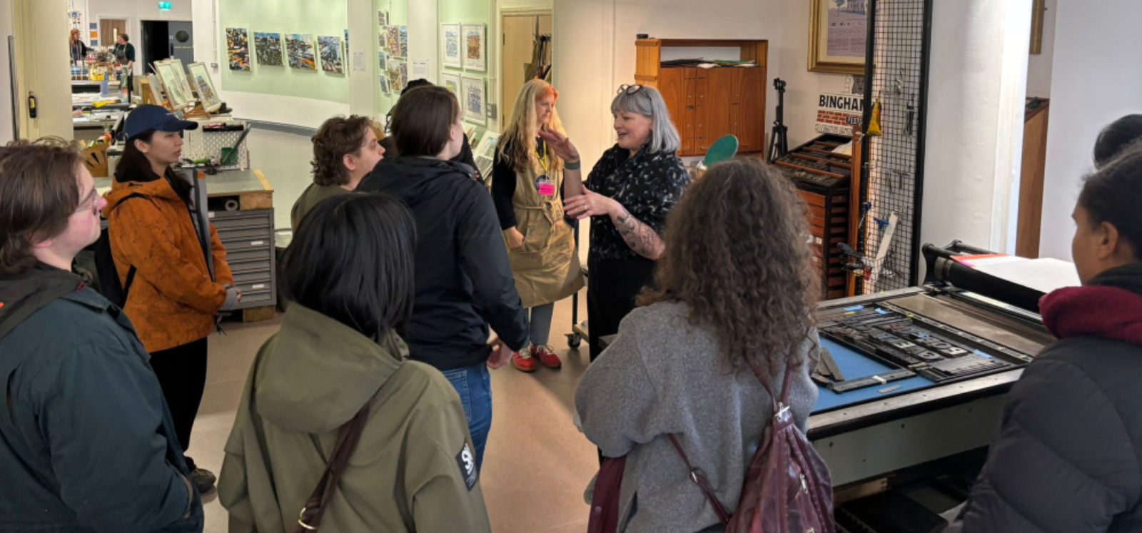Group of people listening to a person giving a talk at a museum