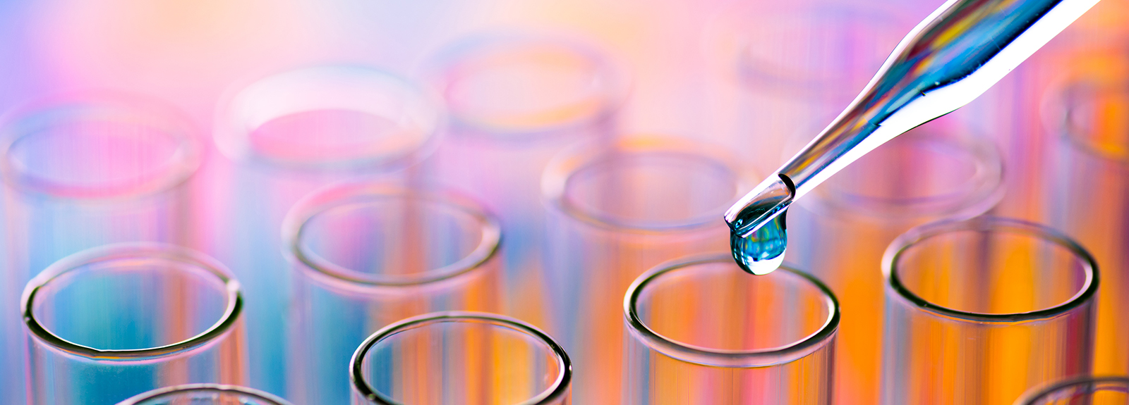 A pipette dropping liquid into test tubes