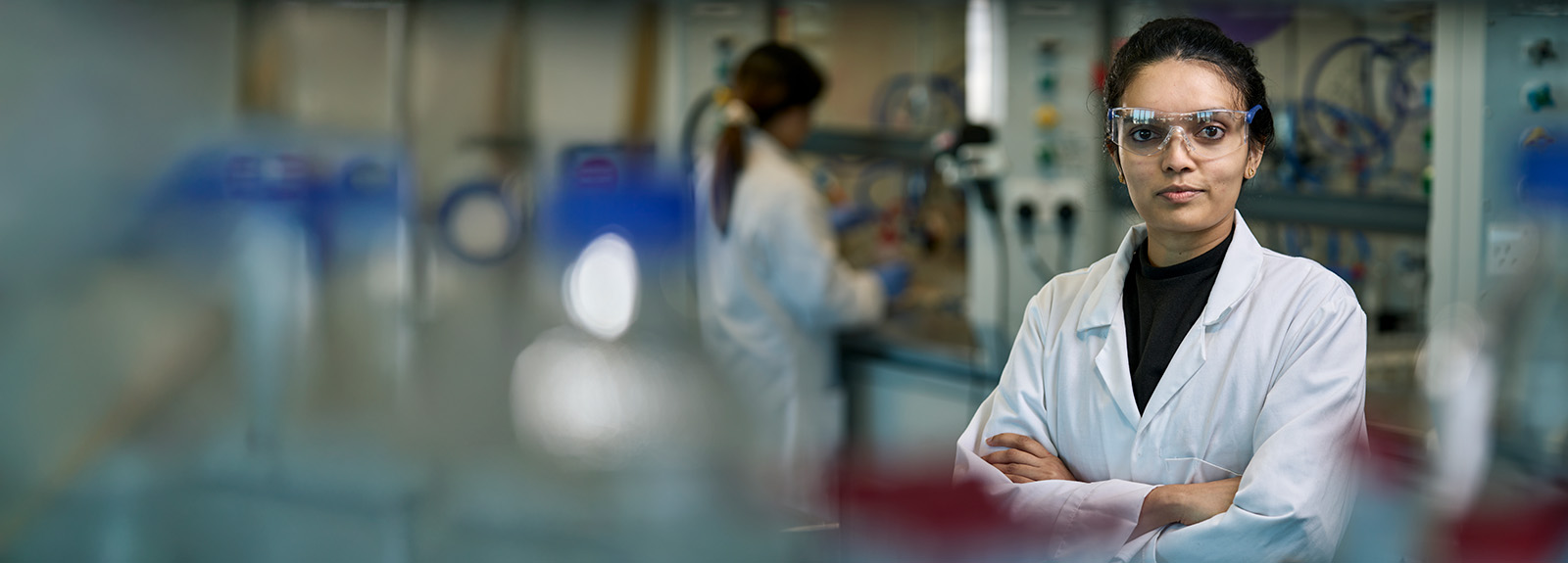 A PhD student standing in a pharmaceutical laboratory