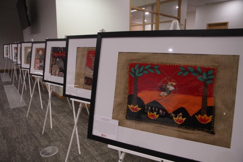 Row of framed textiles on easels