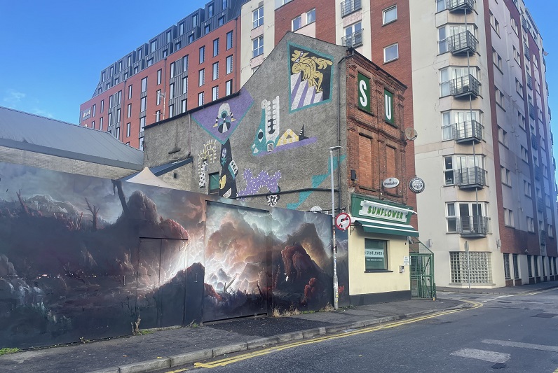 mural on wall adjacent to Sunflower Bar with multi-storey building in background