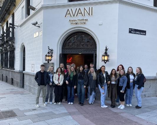 a group of students standing outside the door of their hotel in Madrid