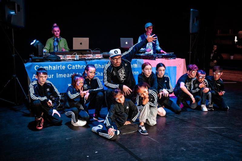 A group of limerockers youth dancers and instructor posing for a photo on stage following a performance