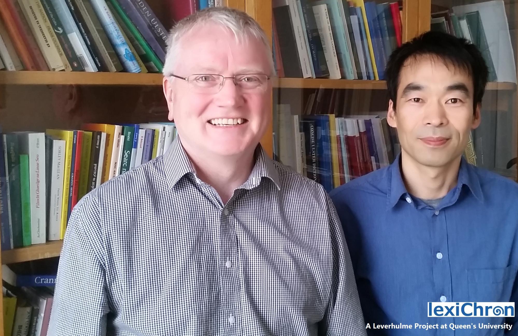 Professor Greg Toner and Dr Xiwu Han smiling and standing in front of bookcase