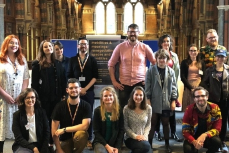 Staff, post-doctoral and post-graduate students in Modern Languages gathered together on the mezzanine area of the Graduate School with those at the back standing and those to the front kneeling.