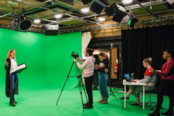 Woman being filmed and interviewed in front of a green screen