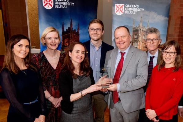 Smiling members of  academic staff being presented with the Vice-Chancellor's prize for research