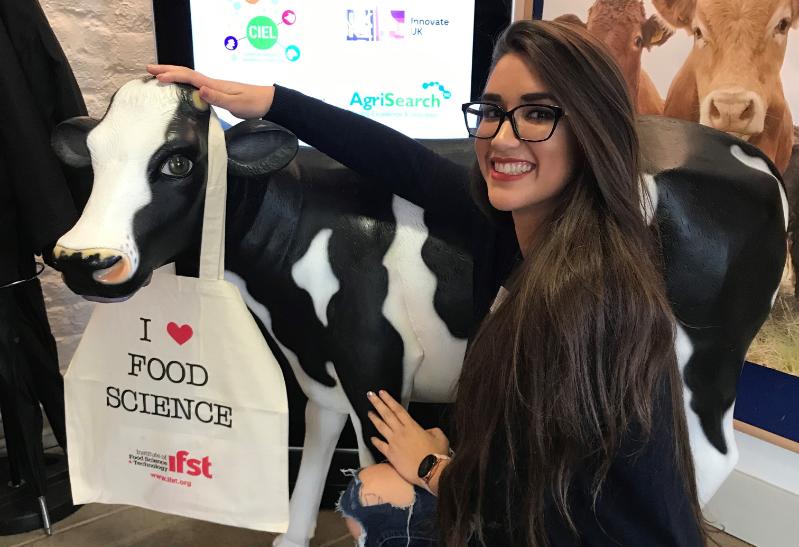 Student posing with a model cow