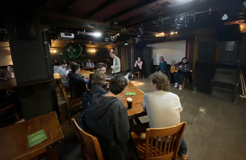 Students sitting in a bar listening to traditional Irish music