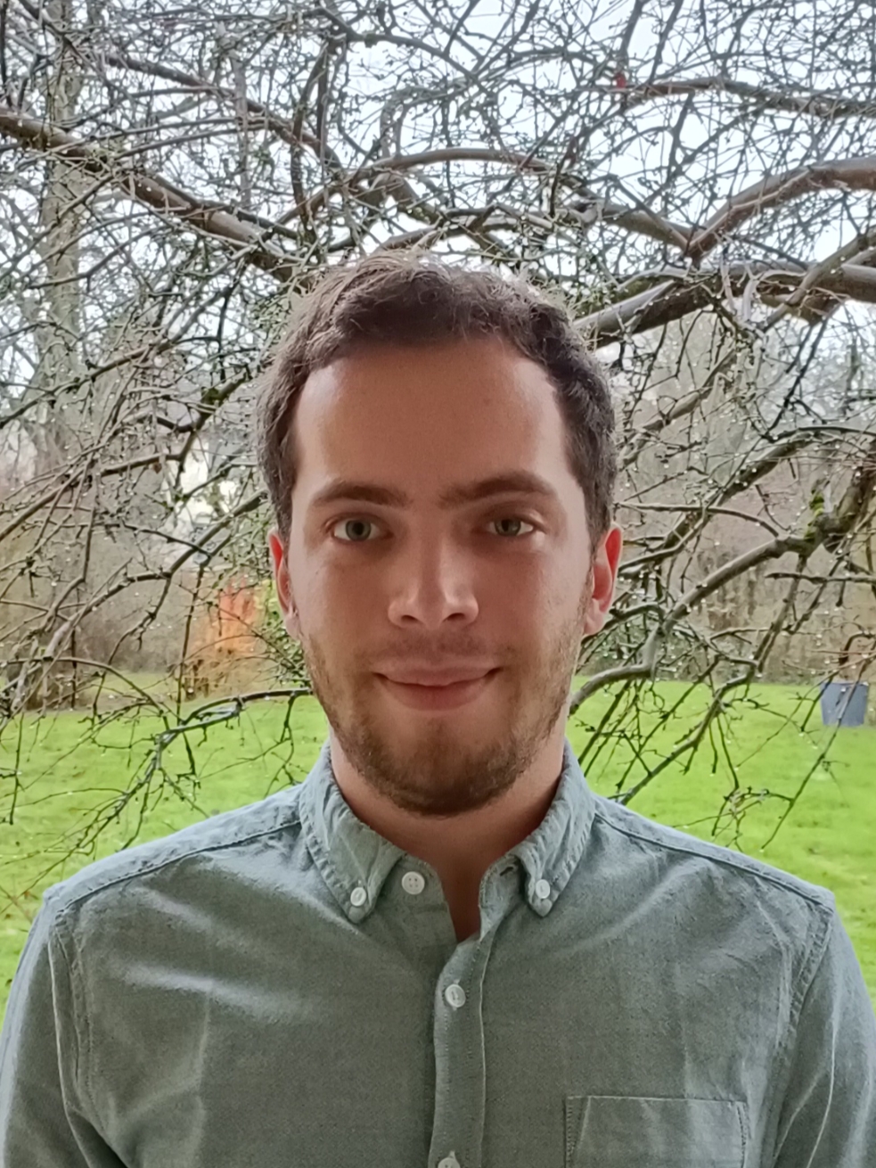 A male student outside , trees in background