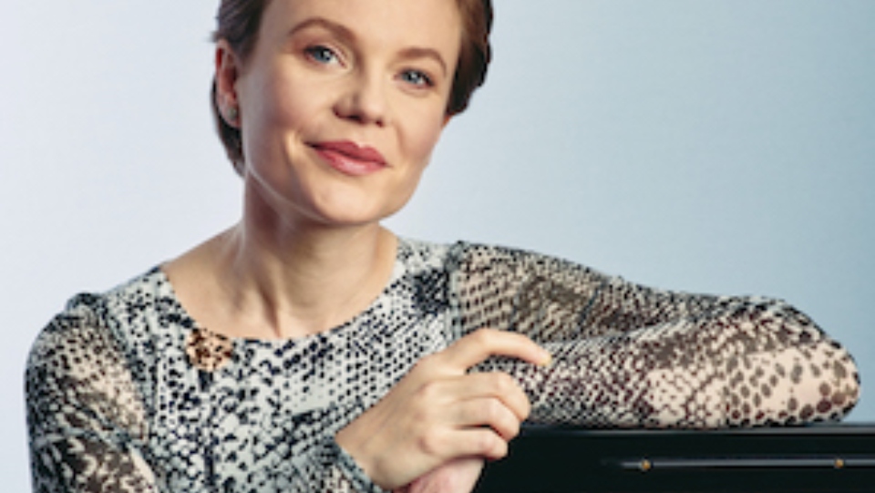 Close up of woman resting against a piano