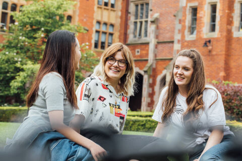 Group of three students talking in the Quad