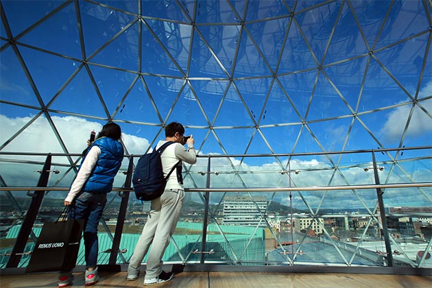 students taking photos of the Belfast skyline from the Dome in Victoria Square Shopping Centre, Belfast