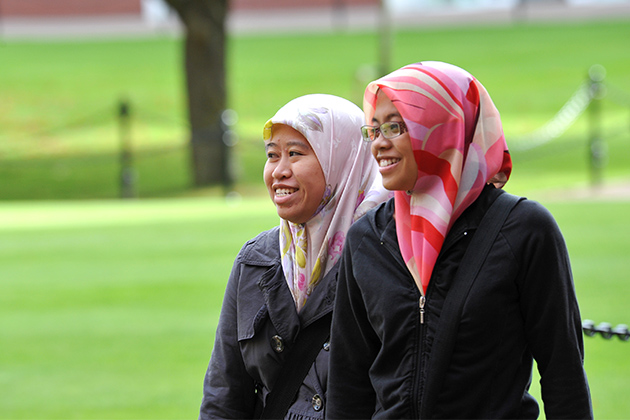 2 female international students walking through the quad