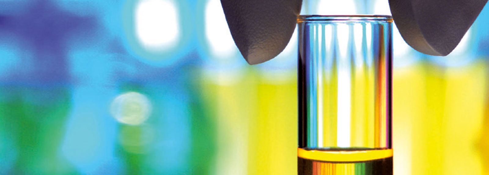 A half-filled test tube set against a colourful backdrop