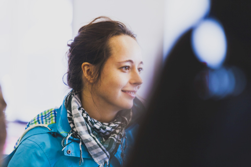 female student wearing a blue coat and chequered scarf on a field trip