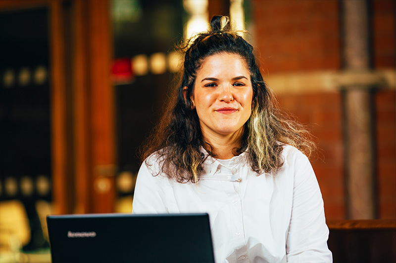 Female postgradaute student working on laptop in graduate school