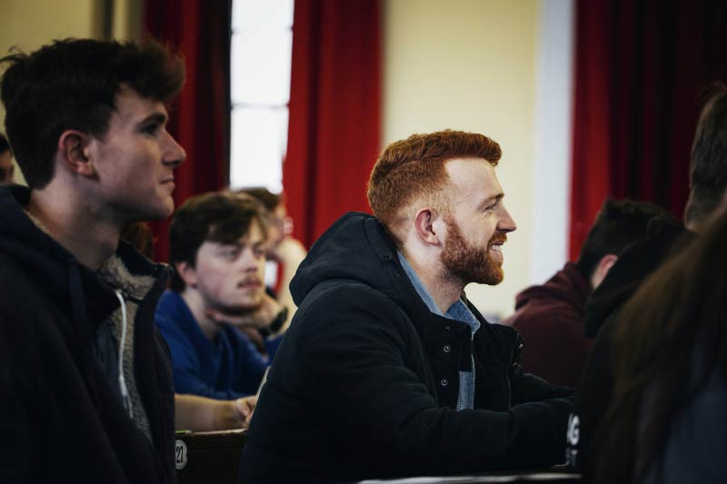 smiling male student in a lecture