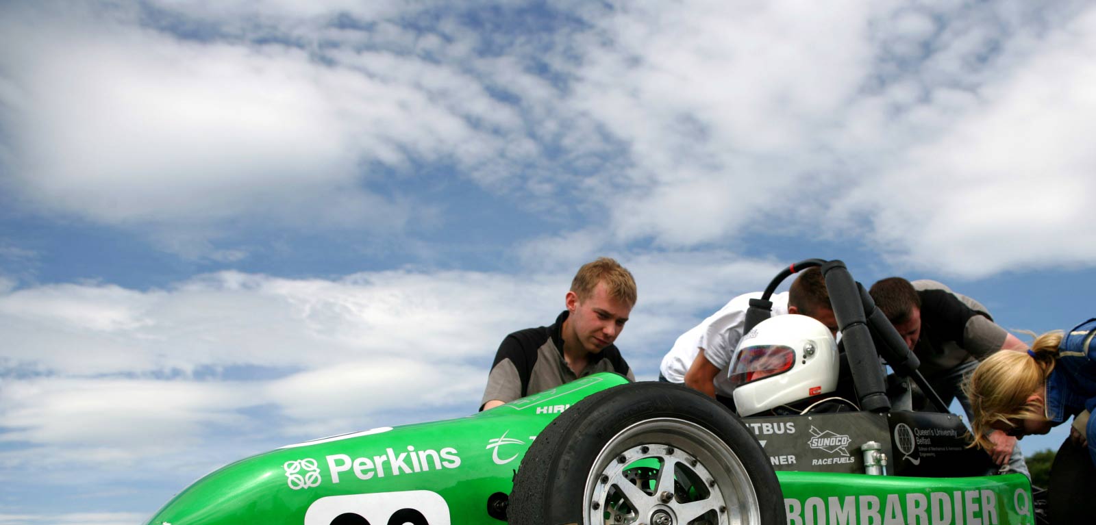 Students working on a formula racing car outside