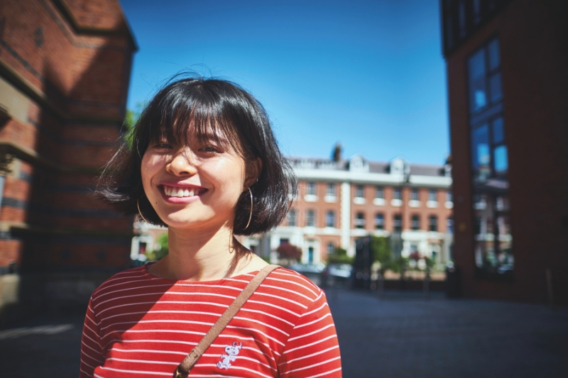 A female student in red top smiling at camera