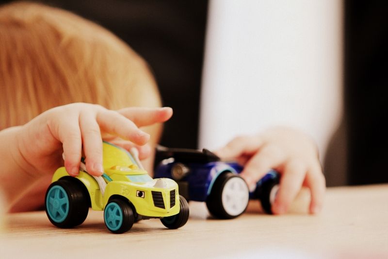 Abstract image of a child playing with toy vehicles