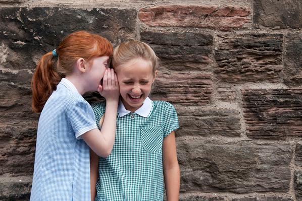 Two schoolgirls whispering