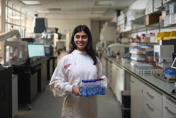 Biological sciences student in lab holding test tubes