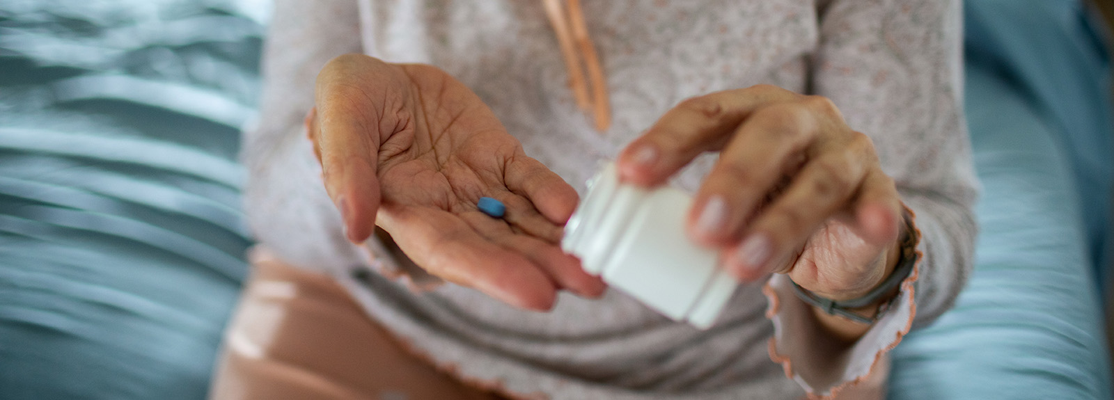 An elderly person taking a tablet