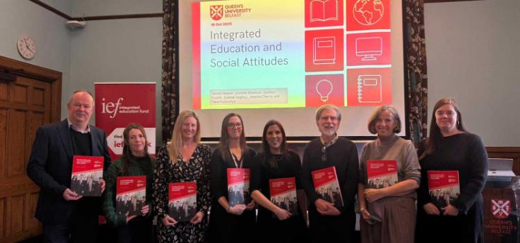 Group photo of researchers from Queen’s University Belfast and Ulster University holding copies of the Social Attitudes and Integrated Education report at its launch event in Riddell Hall.