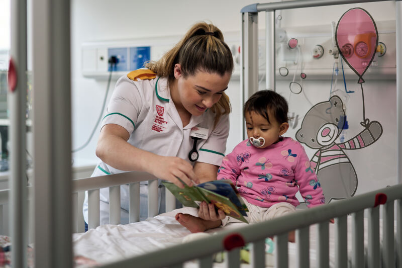 Nursing student with female baby in hospital style setting