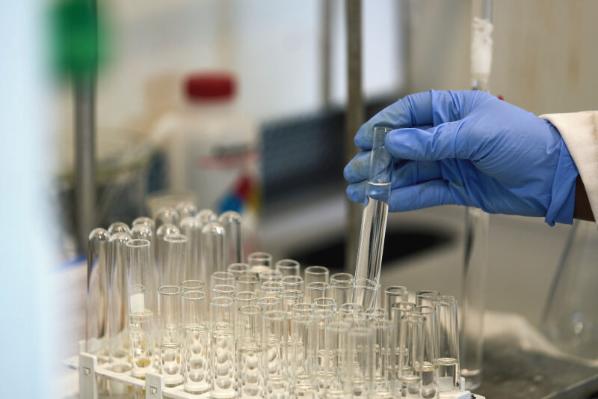 Close up of a researchers hand and test tube in a lab