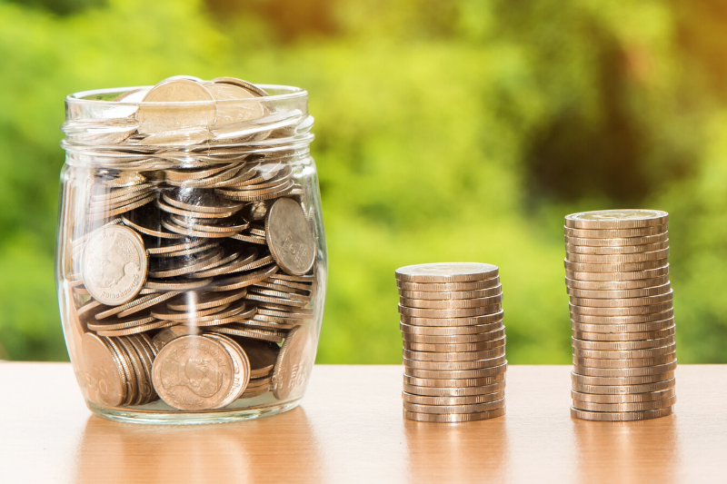 Money Jar and Stacked Coins on a table