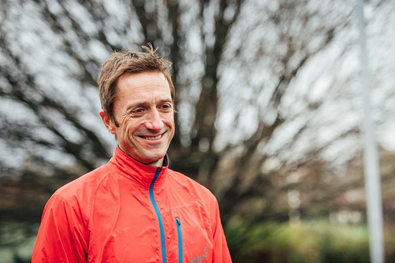 Image of Conor smiling with bright running jacket