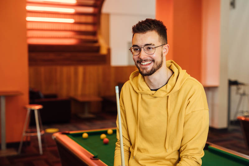 Image of Philip on edge of pool table 