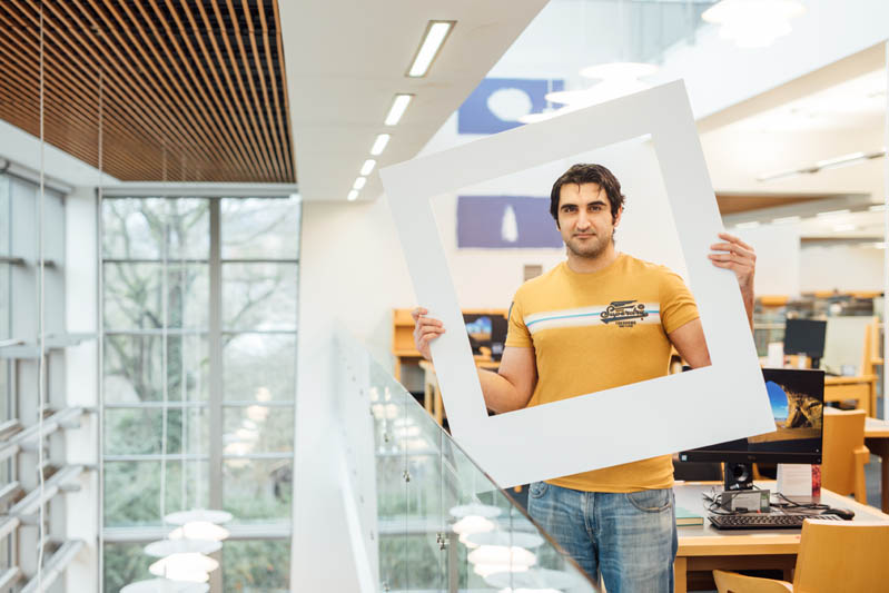 Image of student in McClay library with large polaroid frame